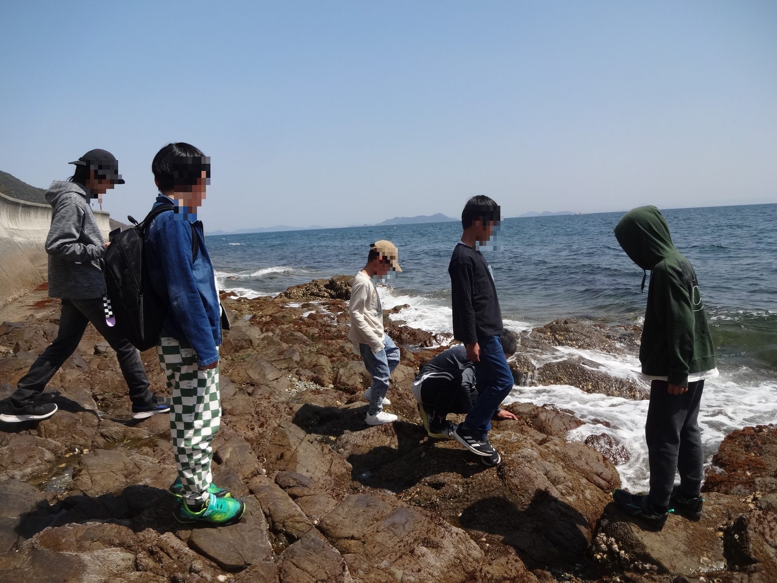 海辺を探検する子どもたちの写真